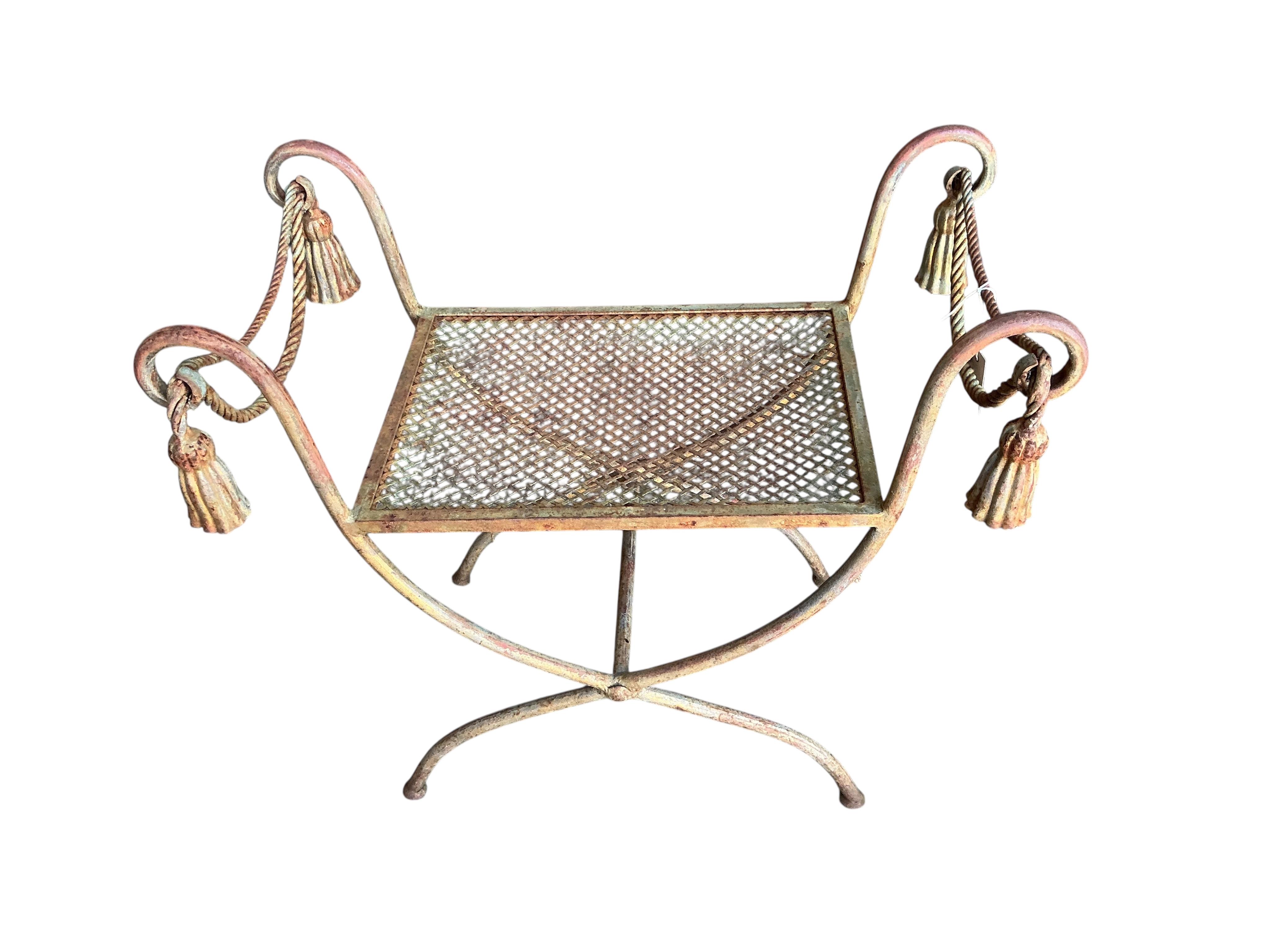 A wrought iron X-framed stool, width 71cm, depth 40cm, height 61cm